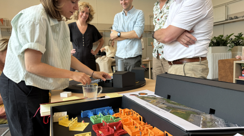 Een ontwerper laat haar ideeën zien met een maquette.