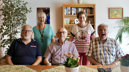 De vijf leden van de bewonerscommissie poseren in de gemeenschappelijke ruimte in het woongebouw