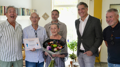Ab, zijn familieleden en collega's van Staedion poseren voor een foto