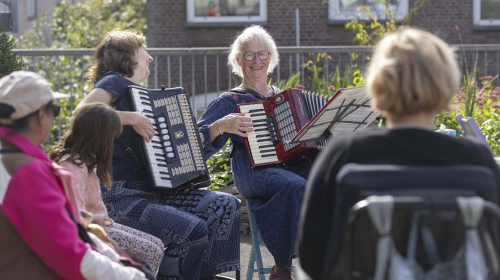 Buren luisteren naar muziek tijdens Burendag op het Kepplerplein