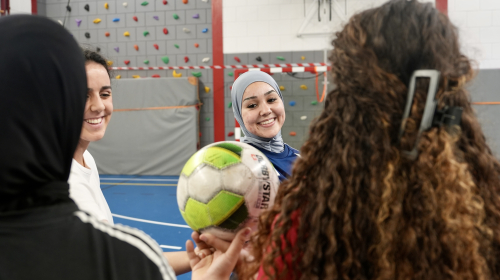 Vier meisjes met een bal in een sporthal