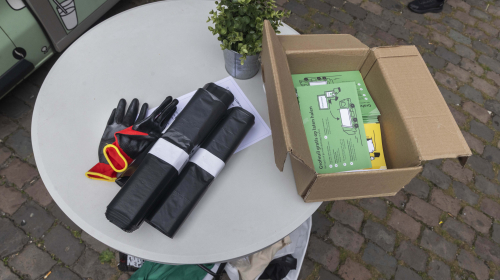 Handschoenen, vuilniszakken en flyers liggen klaar voor de opruimactie bij de Lamel.