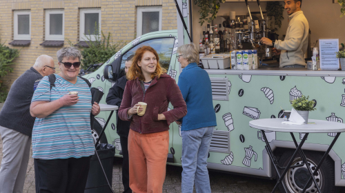 Bewoners staan voor de koffiekar