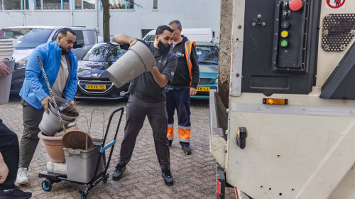 Bloempotten worden door vrijwilliger in de vuilniswagen gegooid