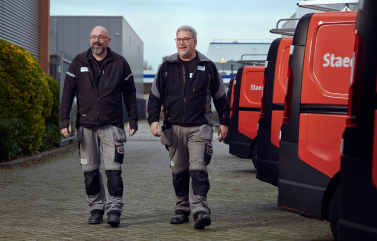 Twee collega's van de afdeling Onderhoud bij hun bussen