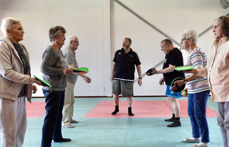 Buurtsportcoach met sportende ouderen