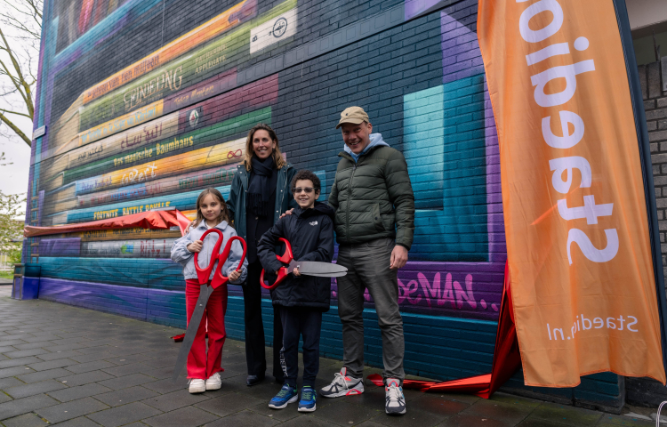 Marieke Stam en de kunstenaar knippen met twee kids het lint door