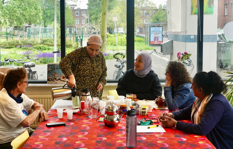 Vrouwenbuurtlab in Spoorwijk drinken koffie aan tafel