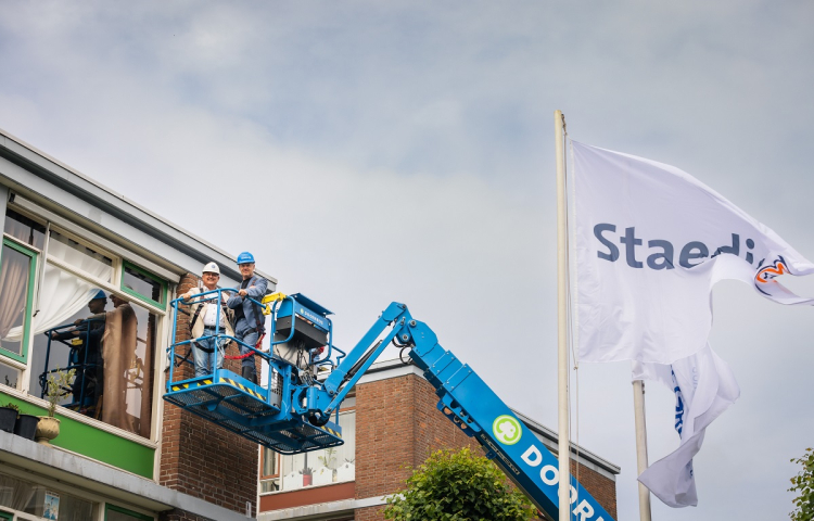 Gijsbert van Herk en Olaf de Lange samen in de hoogwerker om een vleermuiskast op te hangen