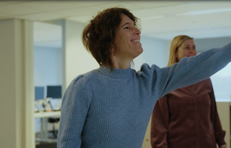Annelies wijst iets aan aan collega