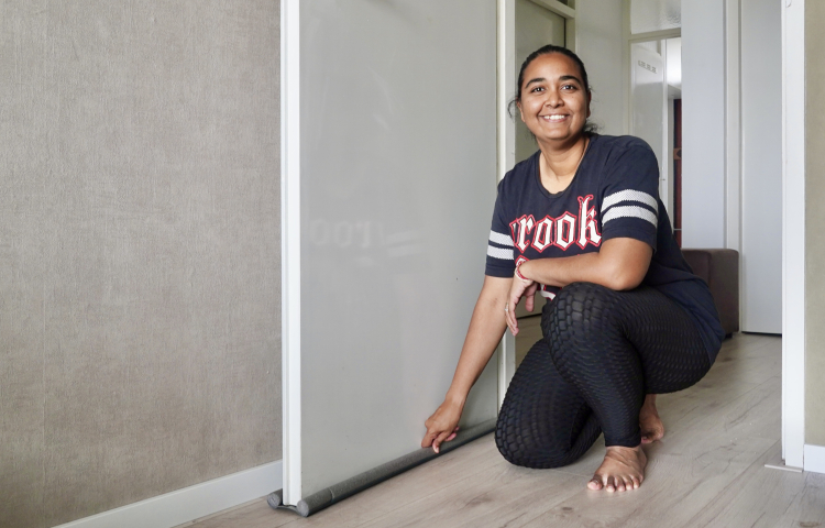 Nisha bewoner behaaglijker wonen poseert in doorgang naast de deur