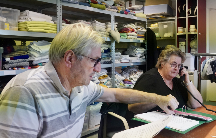  Stien aan de telefoon en Wim met een vel papier in zijn hand