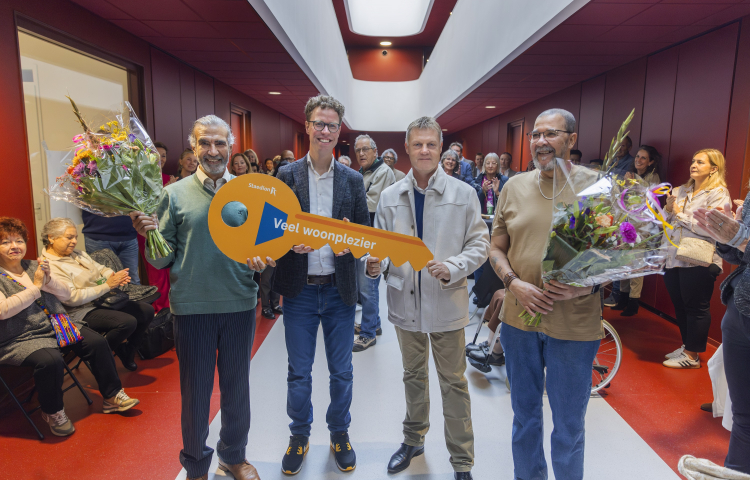 De eerste bewoners ontvangen de symbolische sleutel van hun nieuwe huis