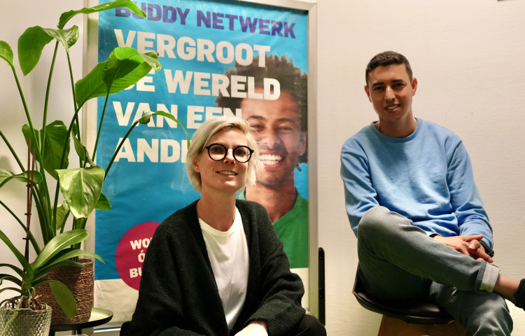 Buddy Netwerk - Ossie en Tessa zittend voor een campagneposter 