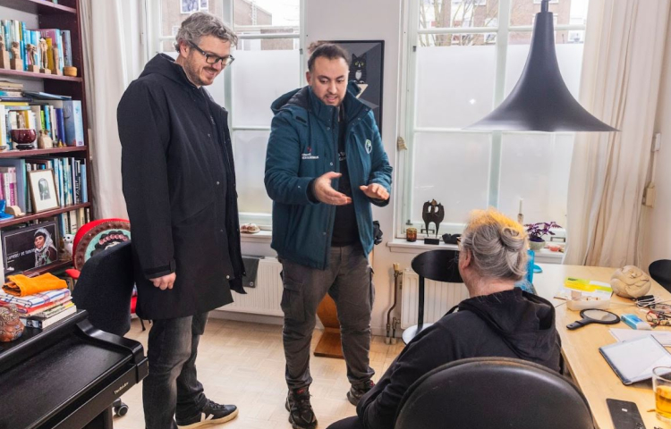 Wethouder Kapteijns en een bewoner krijgen tips voor energie besparen van enrgiefikser Achraf