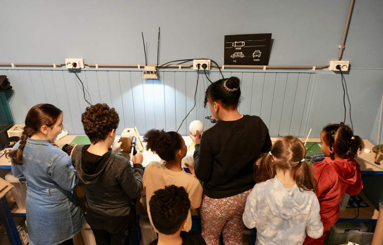 Een groep kinderen aan het werk aan een hoge tafel in het MuseumLab Zicht