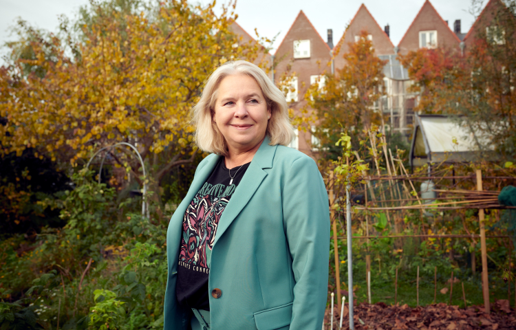 Antoinette gebiedsregisseur staat in een groene tuin de Spinozahof