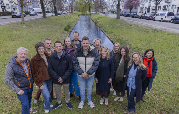 De ontwerpers van Studio Corvers, Overtreders W en Anne van Strien en Daniela Tokashiki gezamenlijk op de foto bij een groenstrook en water in de wijk