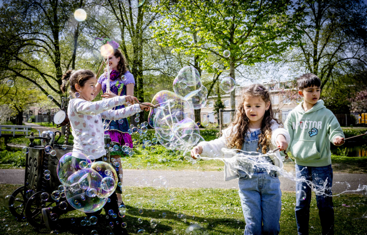 Kinderen spelen buiten met bellenblaas tijdens de feestelijke start van BRUIS