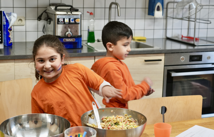 Twee vrolijke kinderen in de keuken