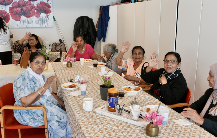 Bewoners van seniorencomplex De Volharding aan tafel om de 25e verjaardag van Staedion te vieren