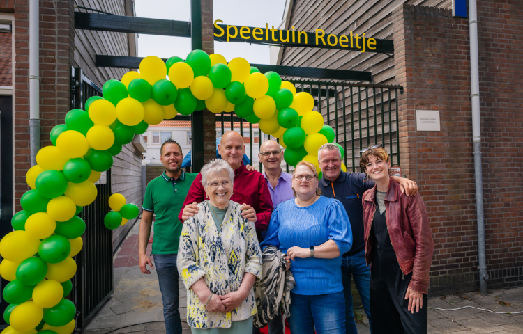Zeven mensen voor Speeltuin Roeltje, bij een boog met ballonnen.