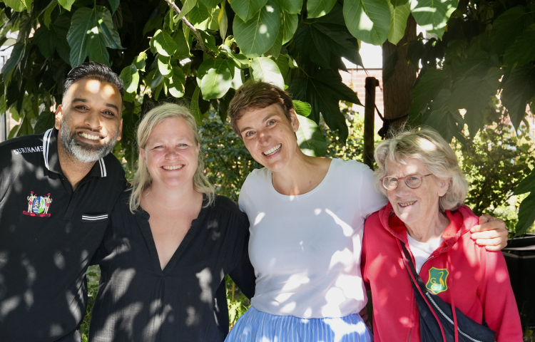 Een meneer en drie dames op een rij onder de boom