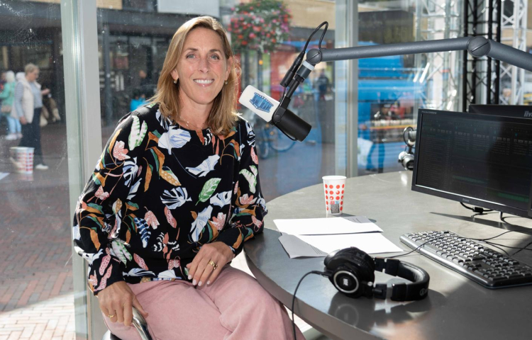 Marieke Stam zit achter een microfoon