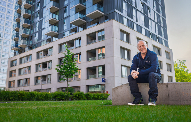 Peter trots zittend voor 'zijn' gebouw
