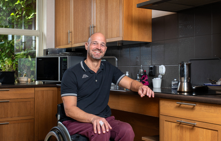 Meneer in rolstoel, in de keuken.