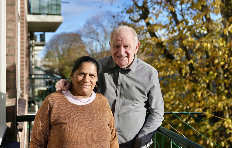 Bea en Pierre poseren op het balkon van hun woning