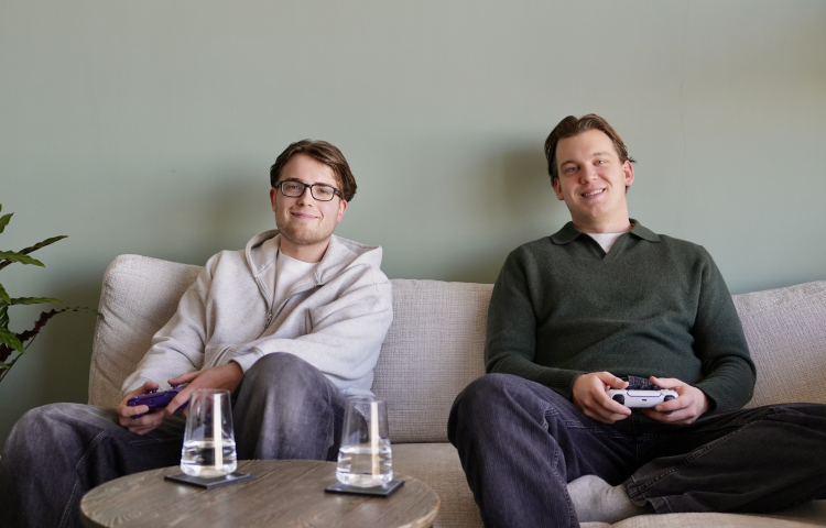 Twee jongens op de bank met een gamecontroller in hun hand