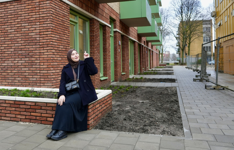 Asli bewoner van Steenzicht zit voor en wijst naar haar nieuwe huis