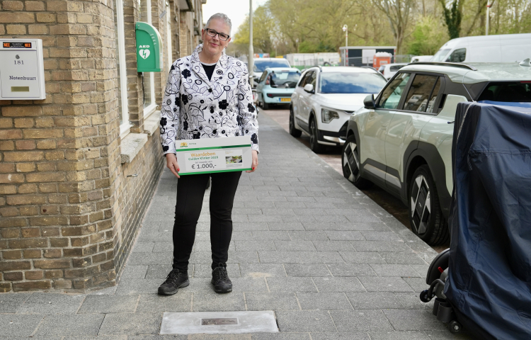 Een mevrouw met in haar handen een waardebon voor de Gulden Klinker
