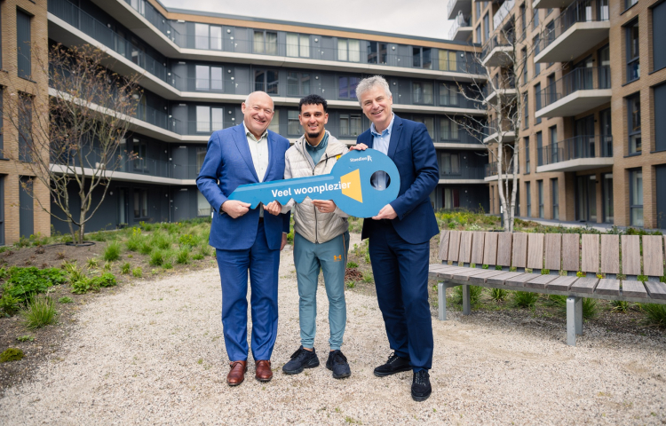Bewoner Ibrahim ontvangt de symbolische sleutel van zijn nieuwe woning