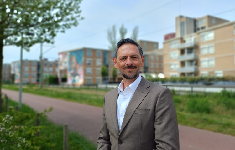 Kay Schellen met op de achtergrond woningen van Staedion aan de Laakweg