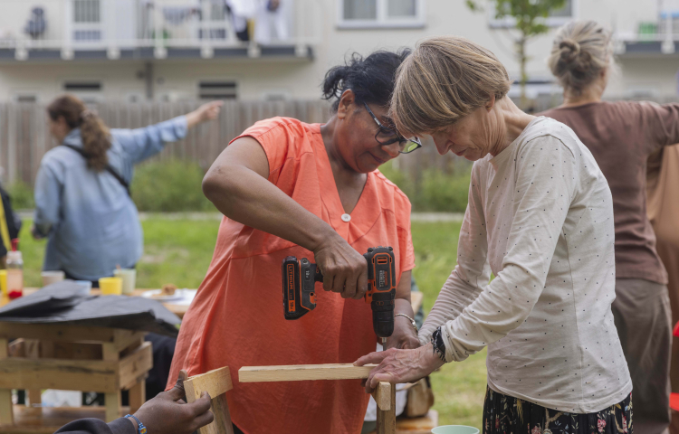 Twee dames maken samen een plantenbak voor aan het balkon