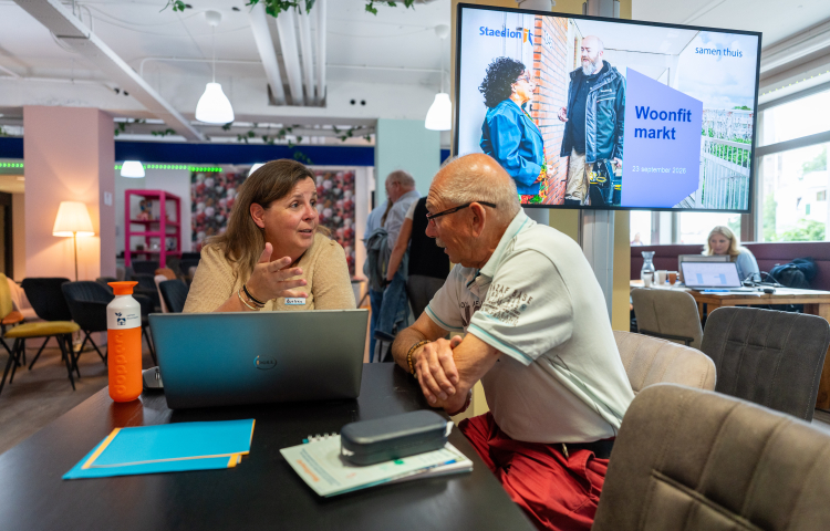 Doorstroommakelaar Evelien in gesprek met een bezoeker van de Woonfitmark