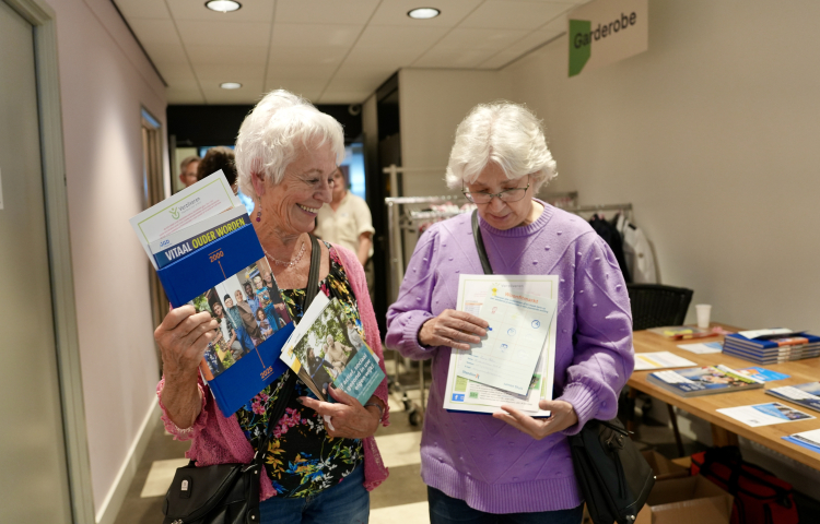 Twee dames op de Woonfitmarkt pakken wat folders