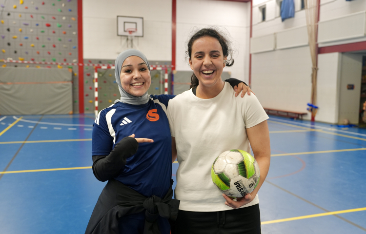 Twee meisjes in een sporthal met een bal in hun hand