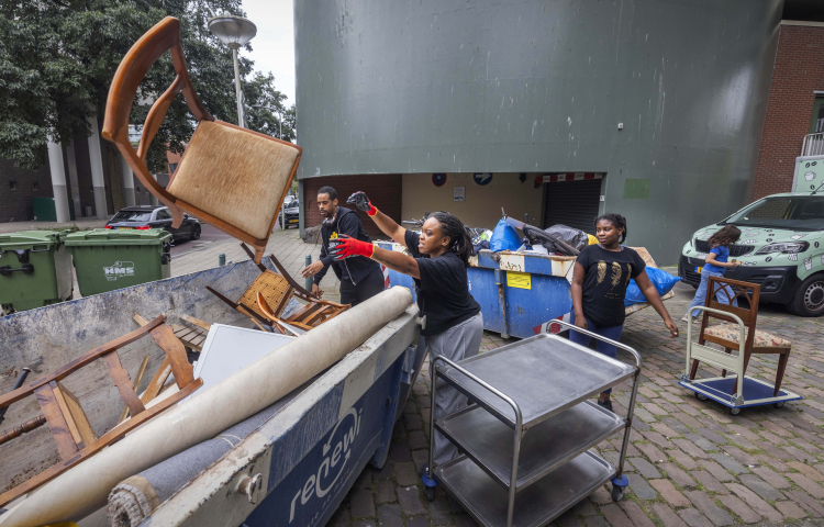 Bewoners van de Lamel gooien grofvuil in de container bij de opruimactie
