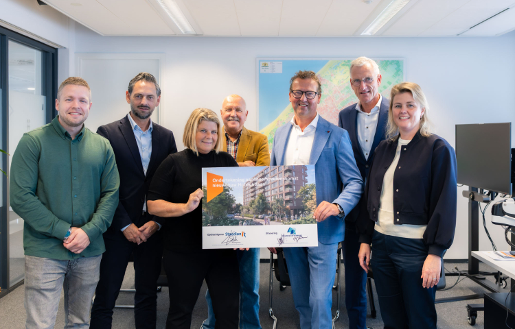 Groep personen rond het bord dat ondertekend is