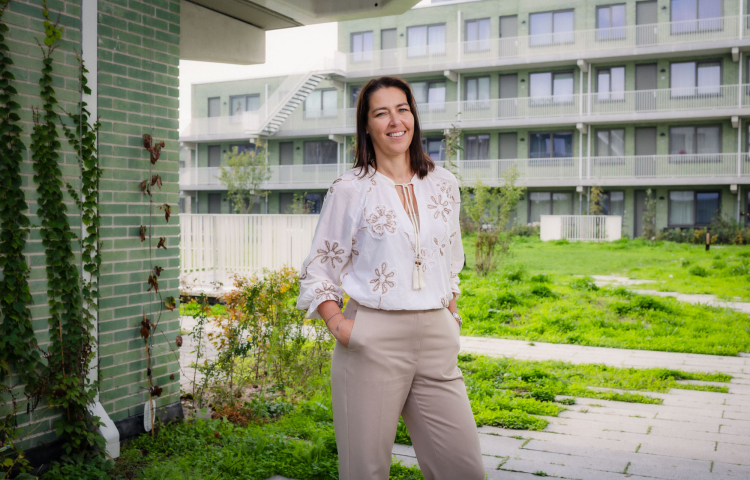 Monique in de tuin met op de achtergrond de woningen van Steenzicht