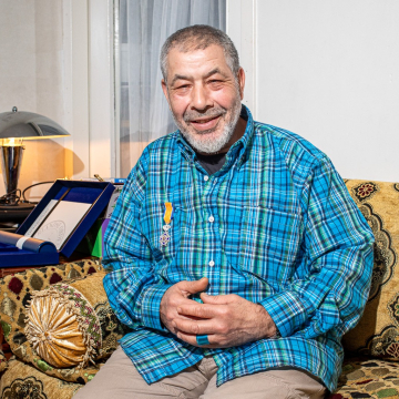 Hassan zit op de bank in zijn woning in Transvaal