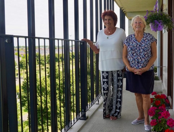 Twee dames staan op hun galerij in Ypenburg