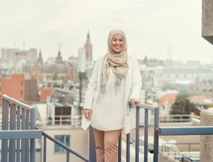 Medewerker Nasira met op de achtergrond de Haagse binnenstad