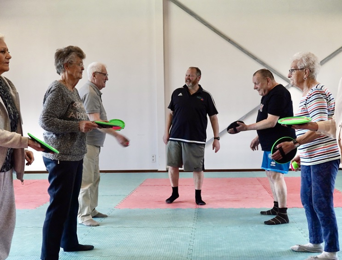 Buurtsportcoach met sportende ouderen