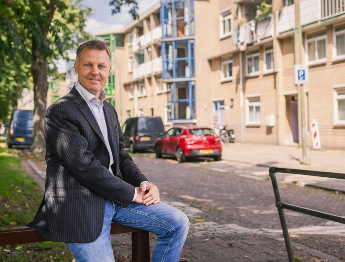 Gijsbert van Herk op hekje voor woningen