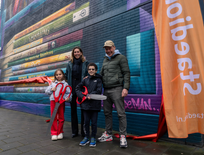 Marieke Stam en de kunstenaar knippen met twee kids het lint door