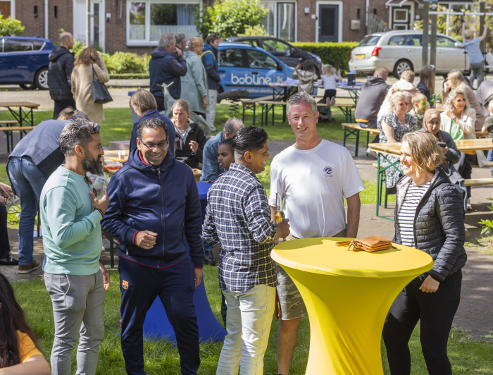 Bezoekers met elkaar in gesprek tijdens het buurtfeest burgemeester scholvinckplein